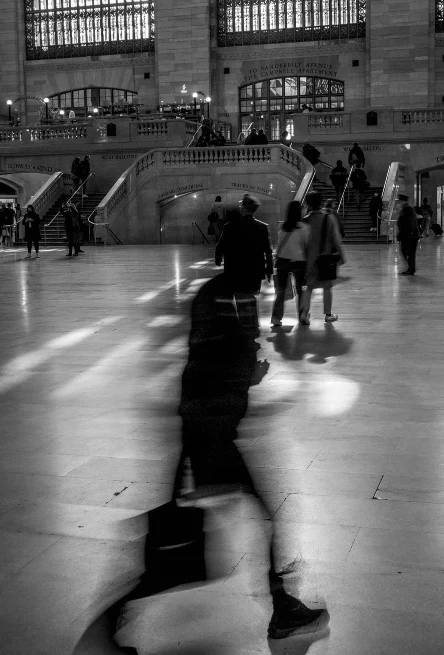 a black and white photo of people in a train station