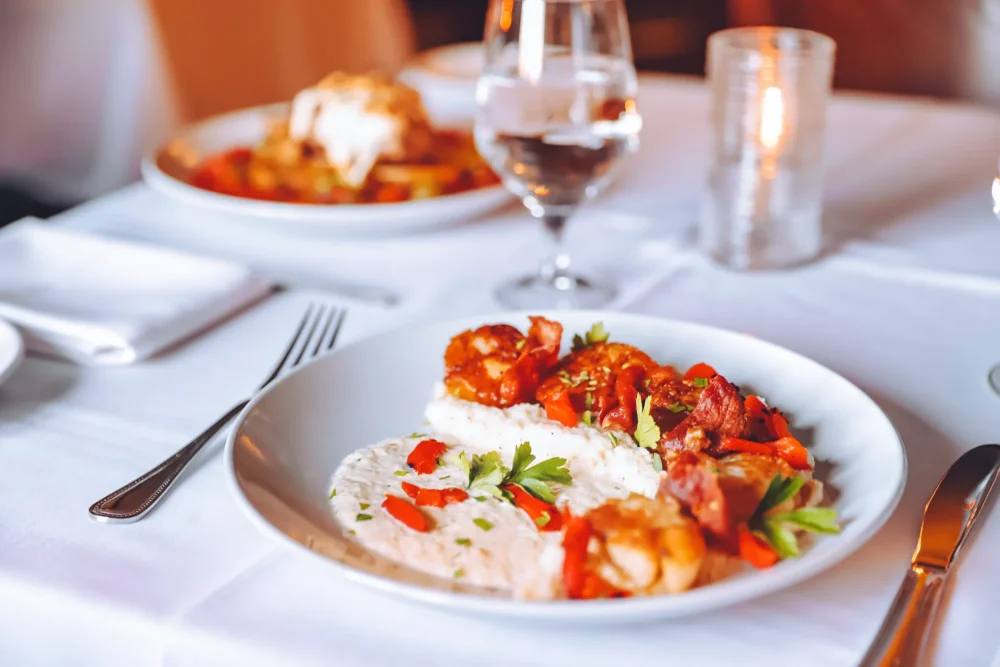 a plate of food on a table with a glass of wine