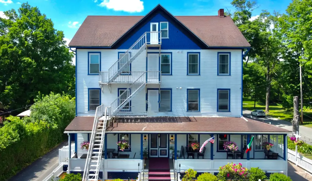 a large blue house with a staircase leading up to it