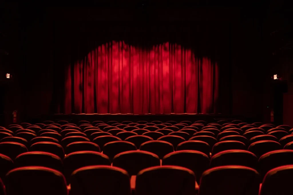 a theater with red curtains and rows of chairs