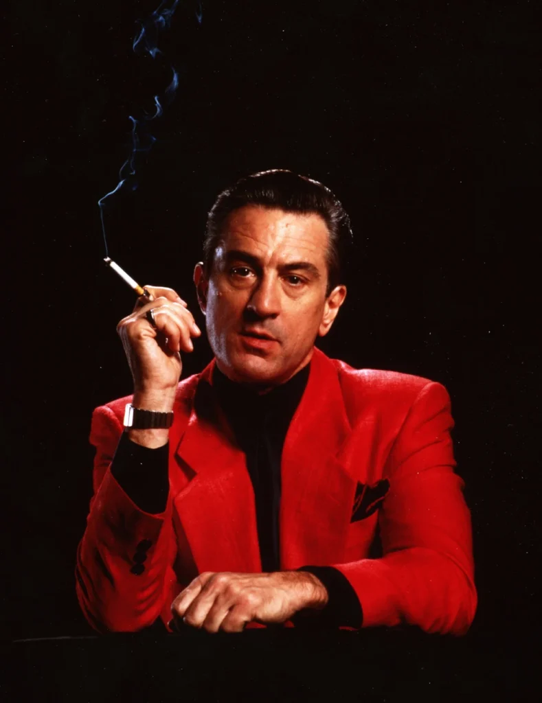 a man in a red suit smoking a cigarette