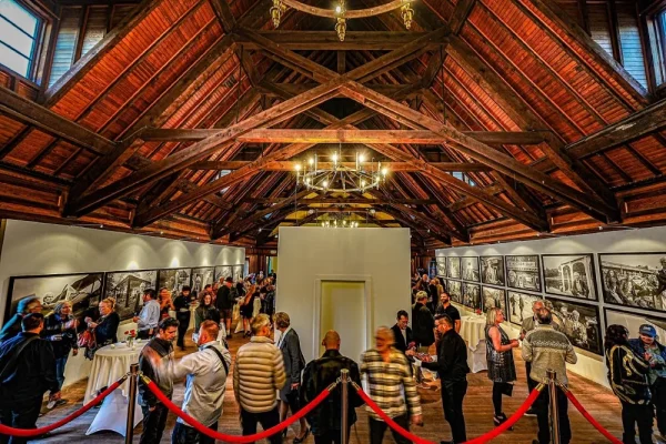 a group of people standing in a room with pictures on the wall