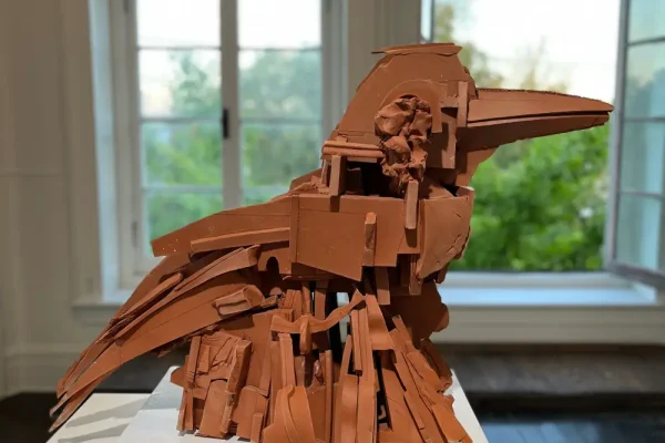 a sculpture of a bird on a white pedestal